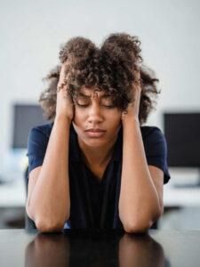 Stressed woman holding head in frustration